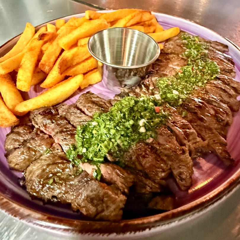 La Gruta's grilled skirt steak with chimichurri sauce and a side of golden french fries.